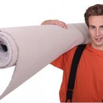 Worker holding a rolled up carpet.