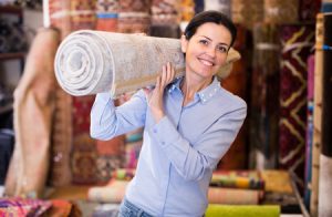 98079402 - woman holding carpet  before buying to her new house interior