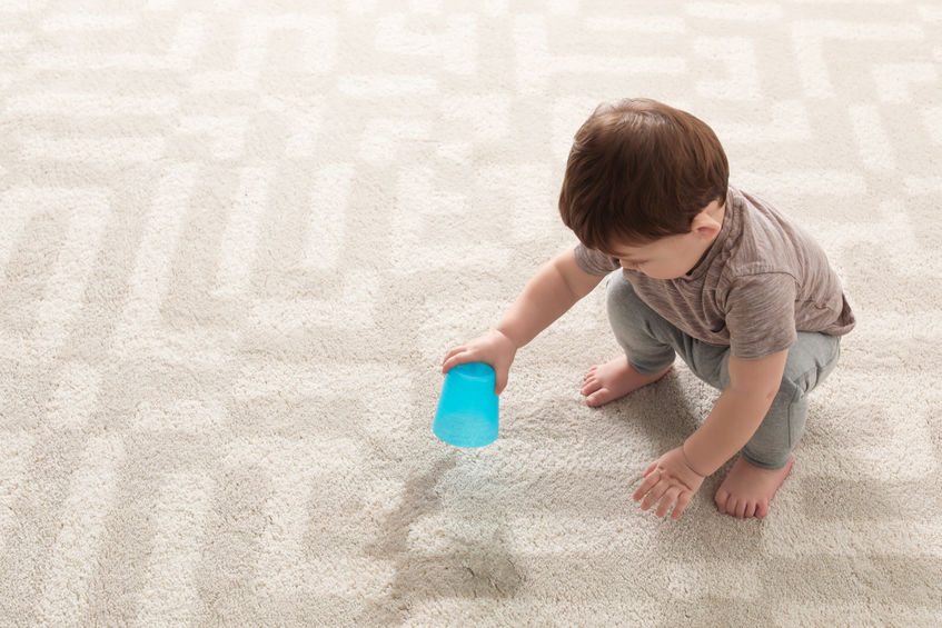 Child spilling drink on new carpet