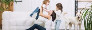 A family with kids and a pet playing on the floor