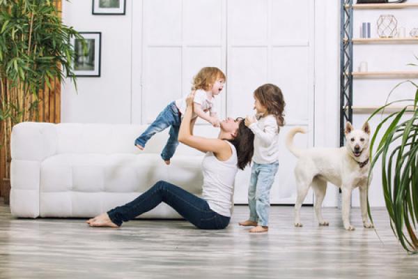 A family with kids and a pet playing on the floor