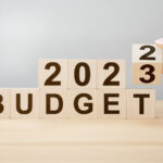 wooden blocks, the bottom row sells "budget" and on top there is "2023"