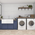 A photo showing a large sink, washer, and dryer on hardwood flooring.