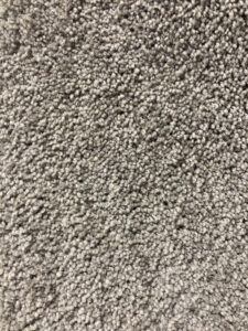 Close-up view of light gray, textured carpet with dense, looped fibers.
