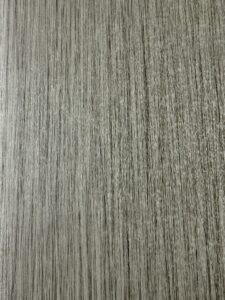 Close-up of a textured surface resembling gray wood grain pattern.